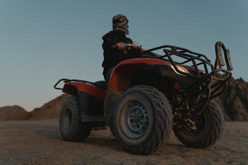 Low Angle Shot of a Man Riding an ATV on the Desert