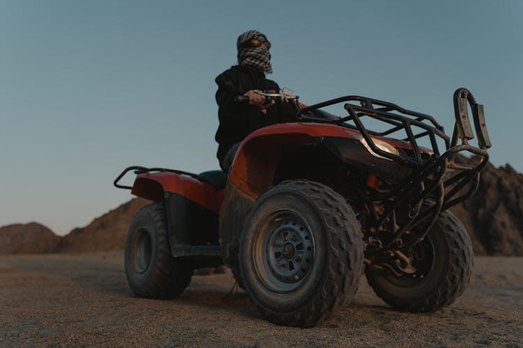 Low Angle Shot Of A Man Riding An ATV On The Desert