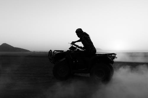 Grayscale Photo of Man Riding ATV