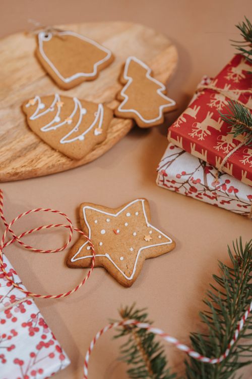 Free Christmas gingerbread cookies and wrapped gifts on a wooden tray with festive decorations. Stock Photo