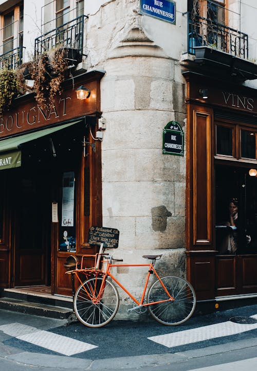 红色城市自行车停在棕色木门旁边