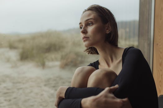 阴天，一个体贴的女人坐在窗边望着外面