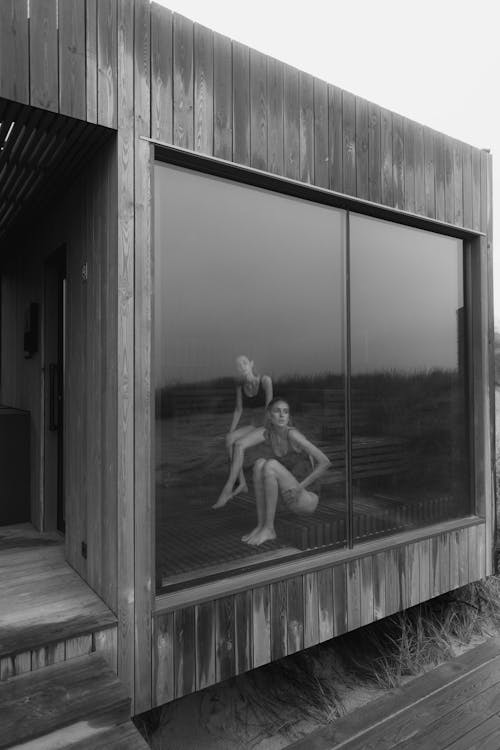 Grayscale Photo of Women inside a Wooden House 