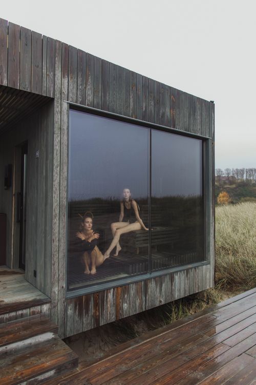 Free Two women relaxing in a sauna with a scenic outdoor view during a rainy day. Stock Photo