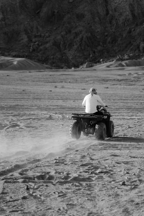 A Man Riding an All Terrain Vehicle in the Desert