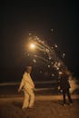 人们晚上在海滩上放烟花庆祝，营造节日气氛