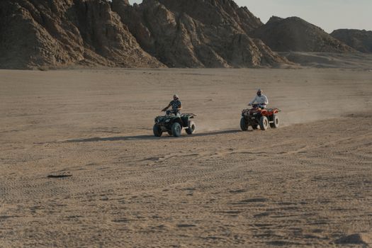 People Riding Atvs on Brown Sand