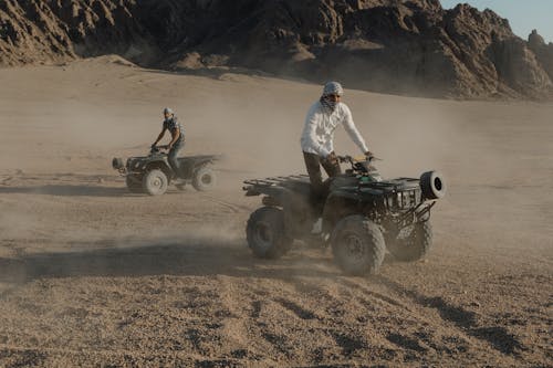 Men Riding Atv Drifting on Desert 