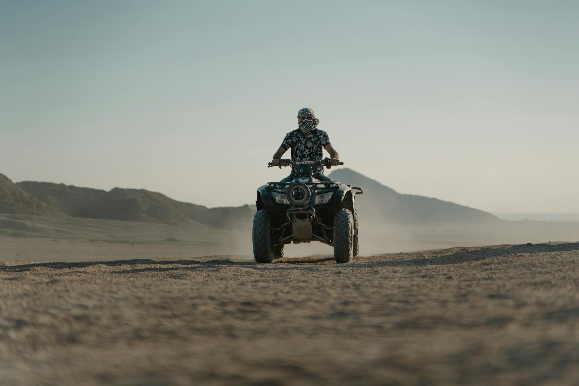 A Man Riding an ATV on a Desert