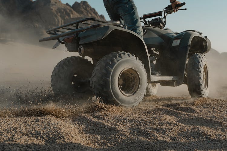 Person Doing Atv Drift On Brown Sand 