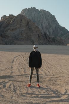 一个人站在沙漠中，背景是山脉，沉默而孤独