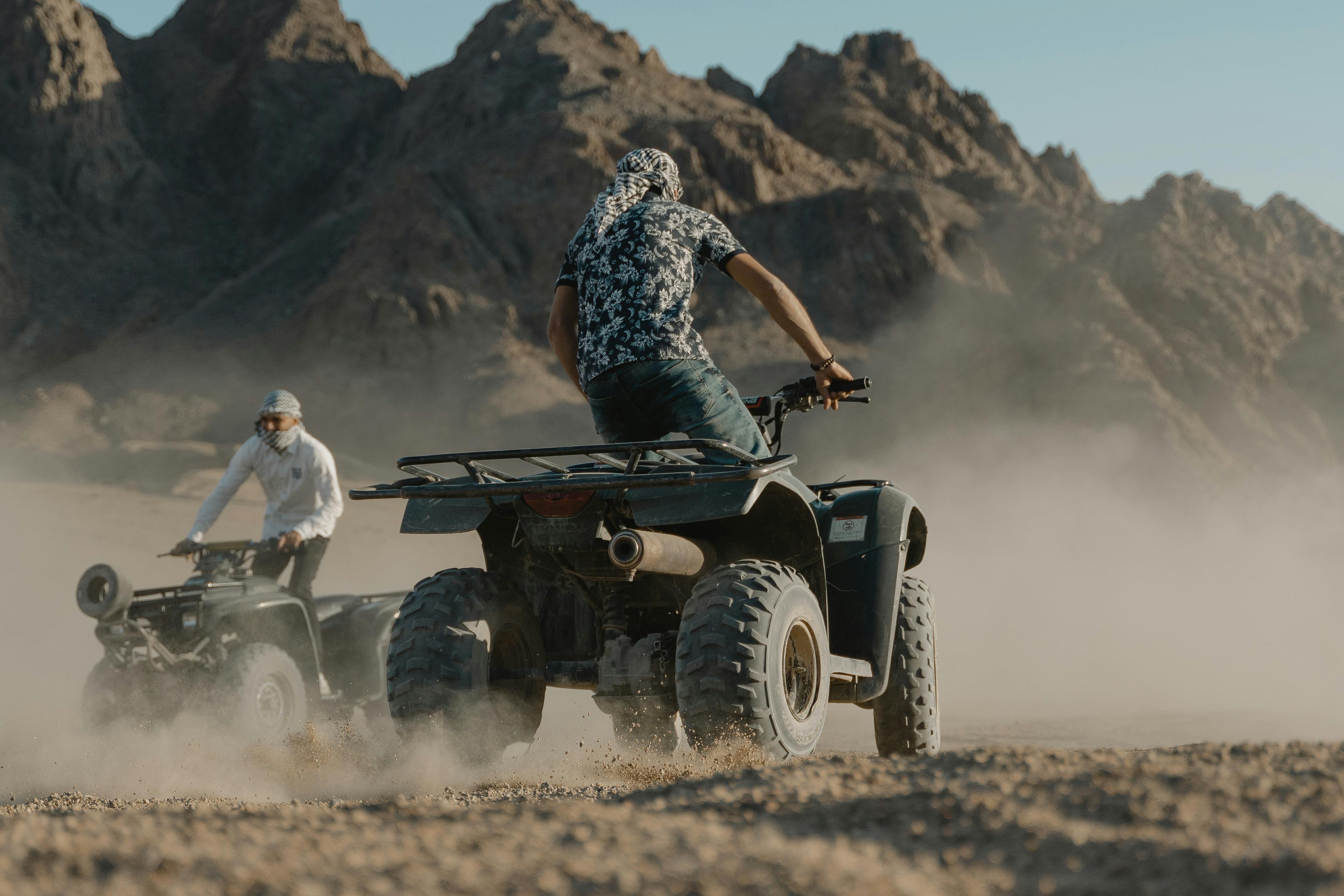 man in black and white floral shirt riding black and white atv