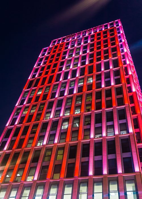 Free Stunning view of a skyscraper with colorful lights against the night sky. Stock Photo