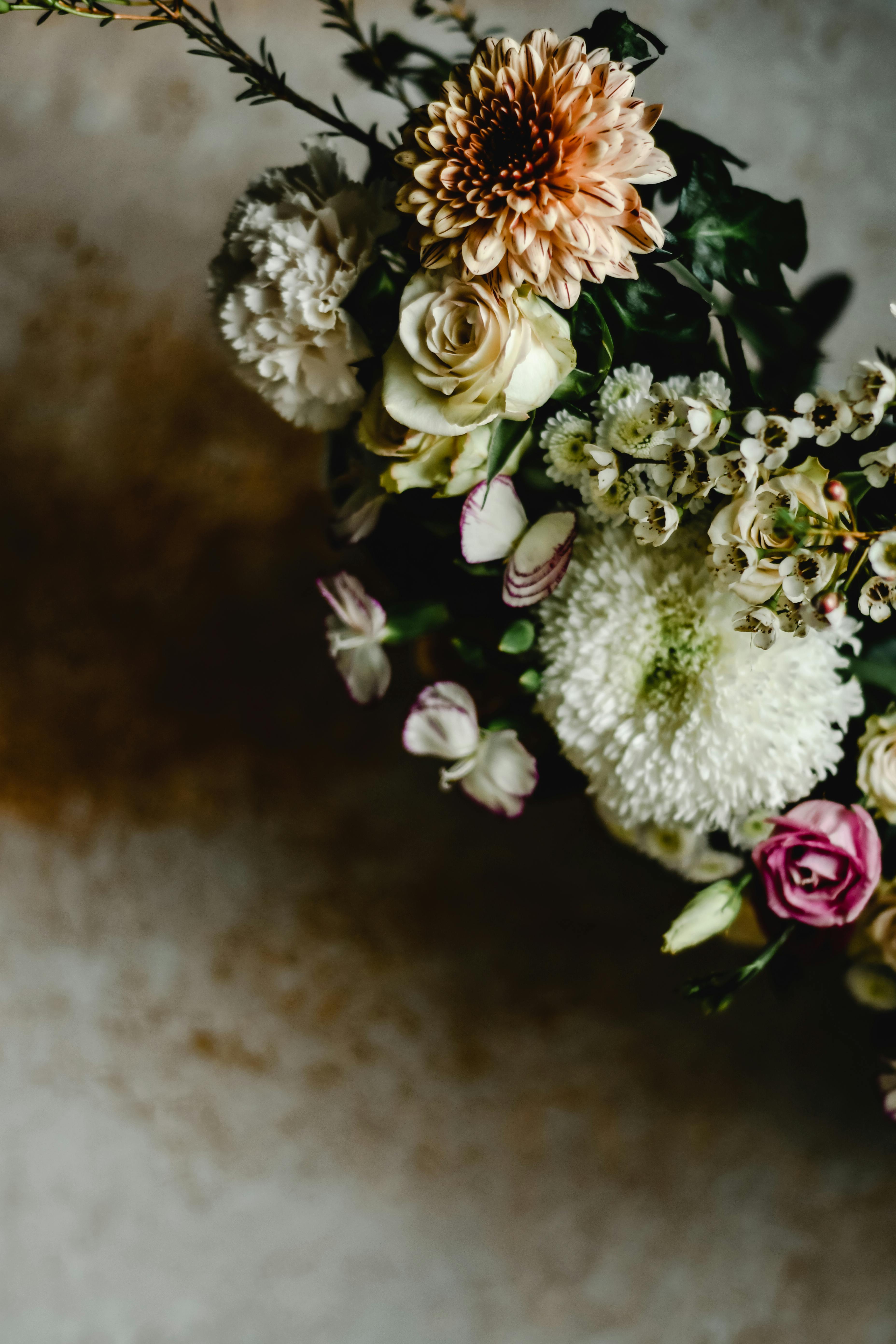 一幅静物画中，充满活力的插花以菊花、玫瑰和康乃馨为特色