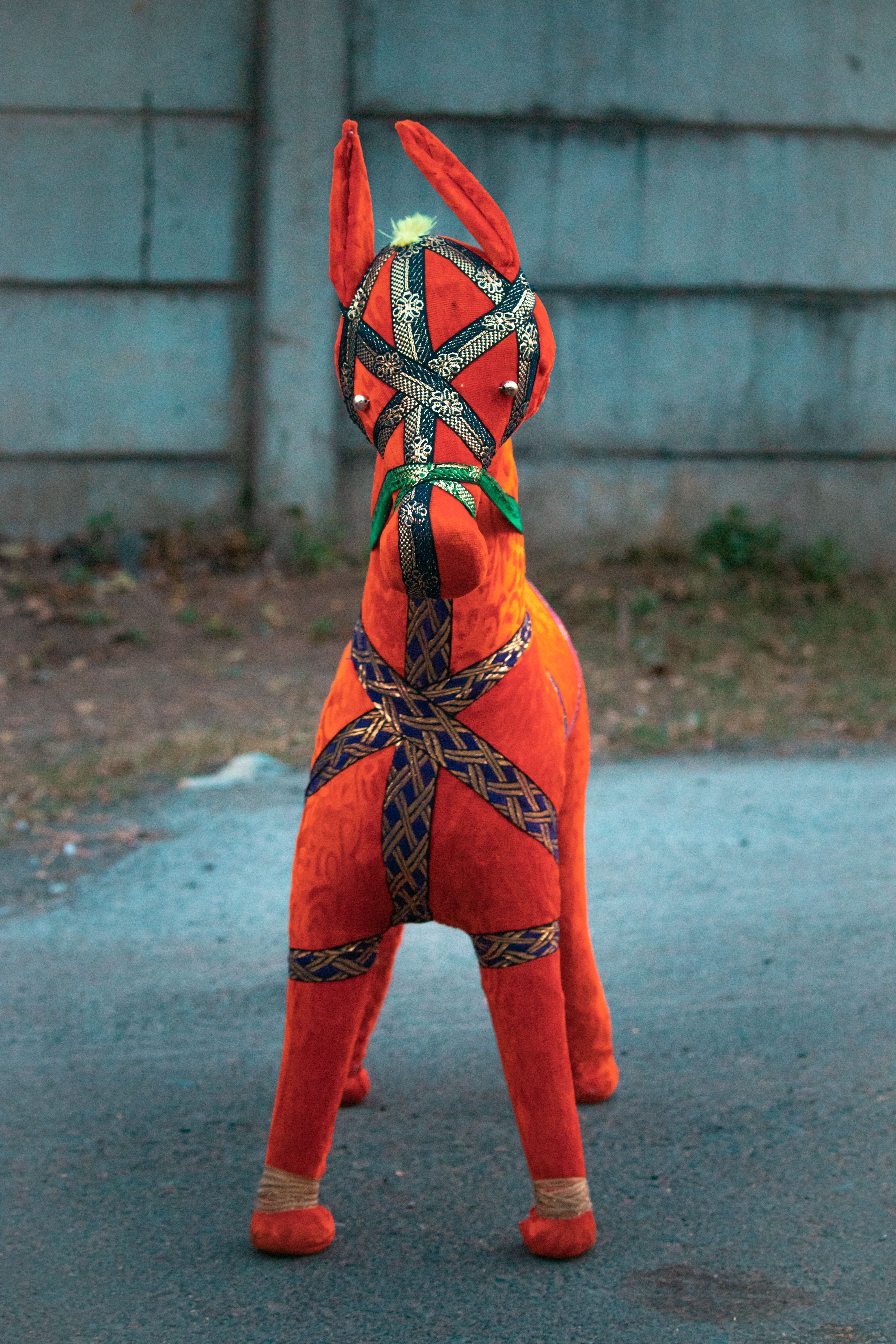 Brightly colored piñata resembling a horse in an outdoor area in Surat, India.
