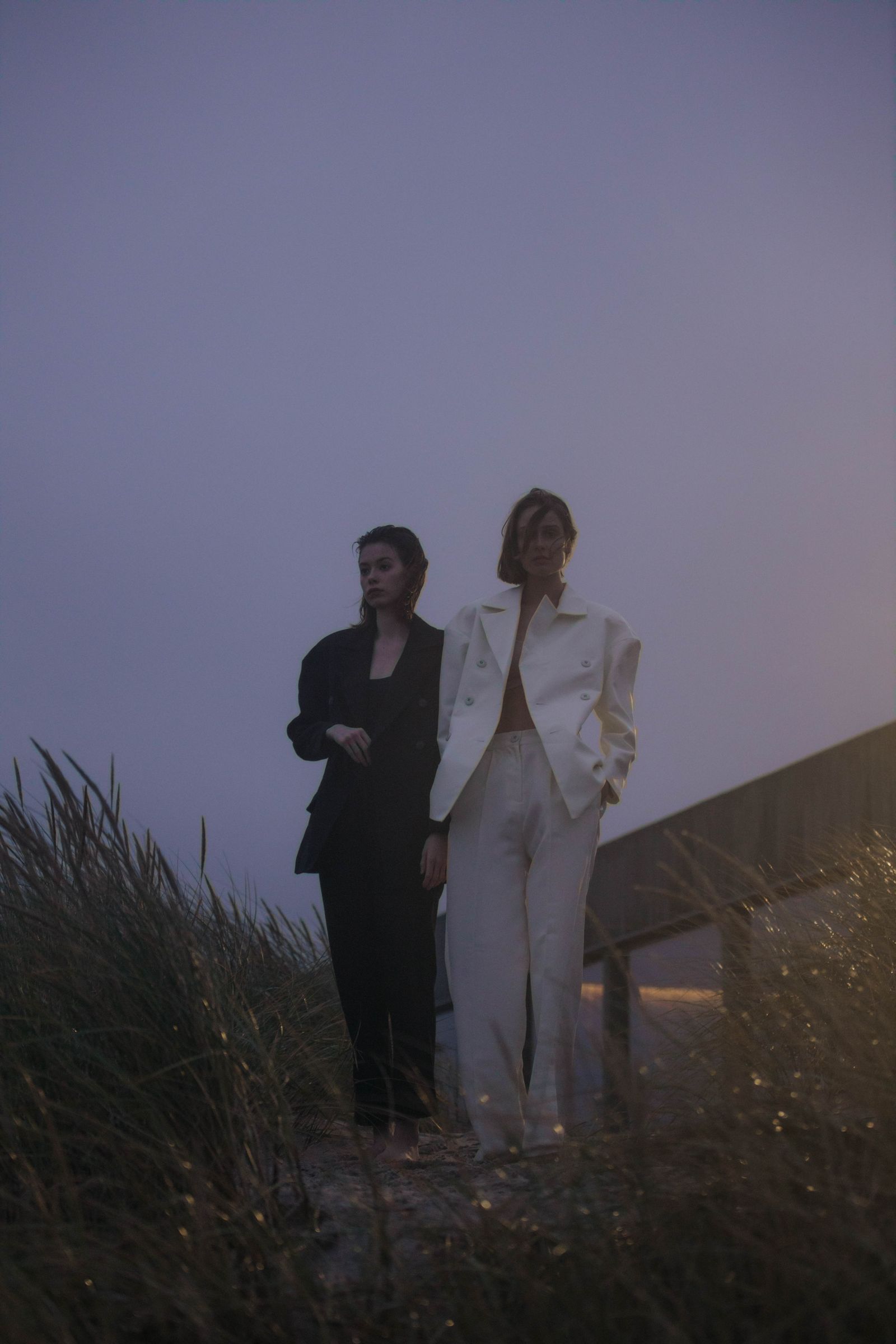Women wearing blazers and tailored trousers standing together