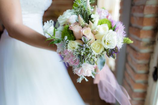 A close-up of a beautiful bridal bouquet with roses at a wedding ceremony.