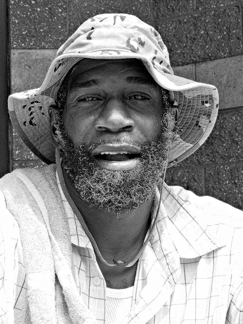 A Grayscale of a Bearded Man Wearing a Hat