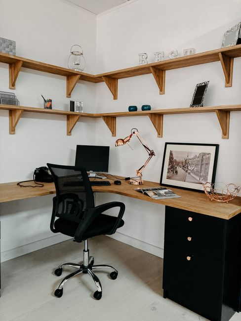 A modern, minimalist home office setup with wooden shelves and sleek furniture.