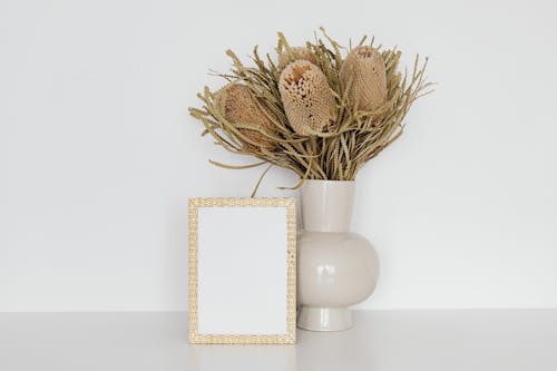 Empty Picture Frame next to Ceramic Vase