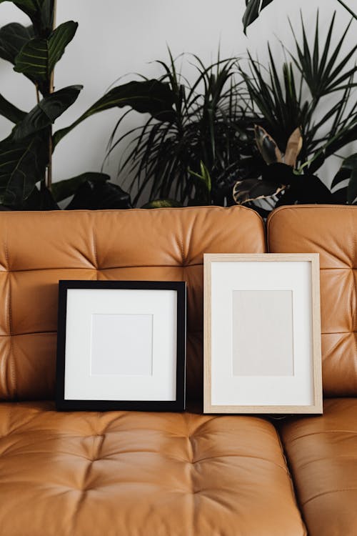 Wooden Picture Frames on Brown Leather Couch 