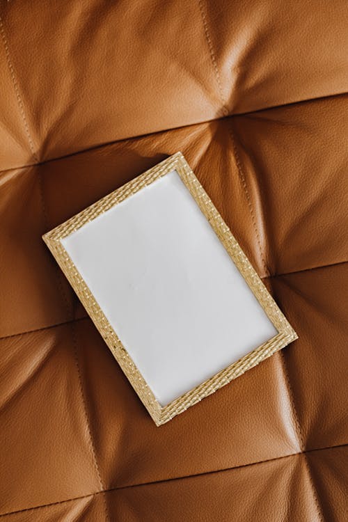 White and Gold Picture Frame on Brown Leather 