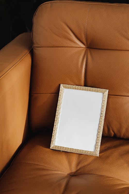 White and Gold Picture Frame on Brown Leather Couch