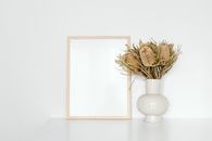 Brown Wooden Picture Frame Beside the Dried Showy Banksia Flowers