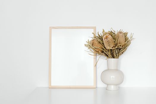 Brown Wooden Picture Frame Beside the Dried Showy Banksia Flowers