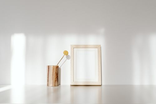 Free Minimalist photo frame and vase on a white surface with natural shadows. Stock Photo