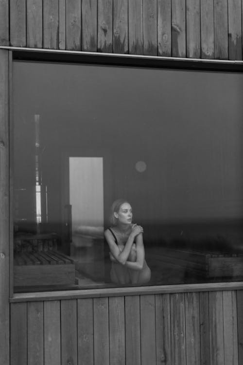 Free Grayscale Photo of Woman Sitting near the Glass Window  Stock Photo