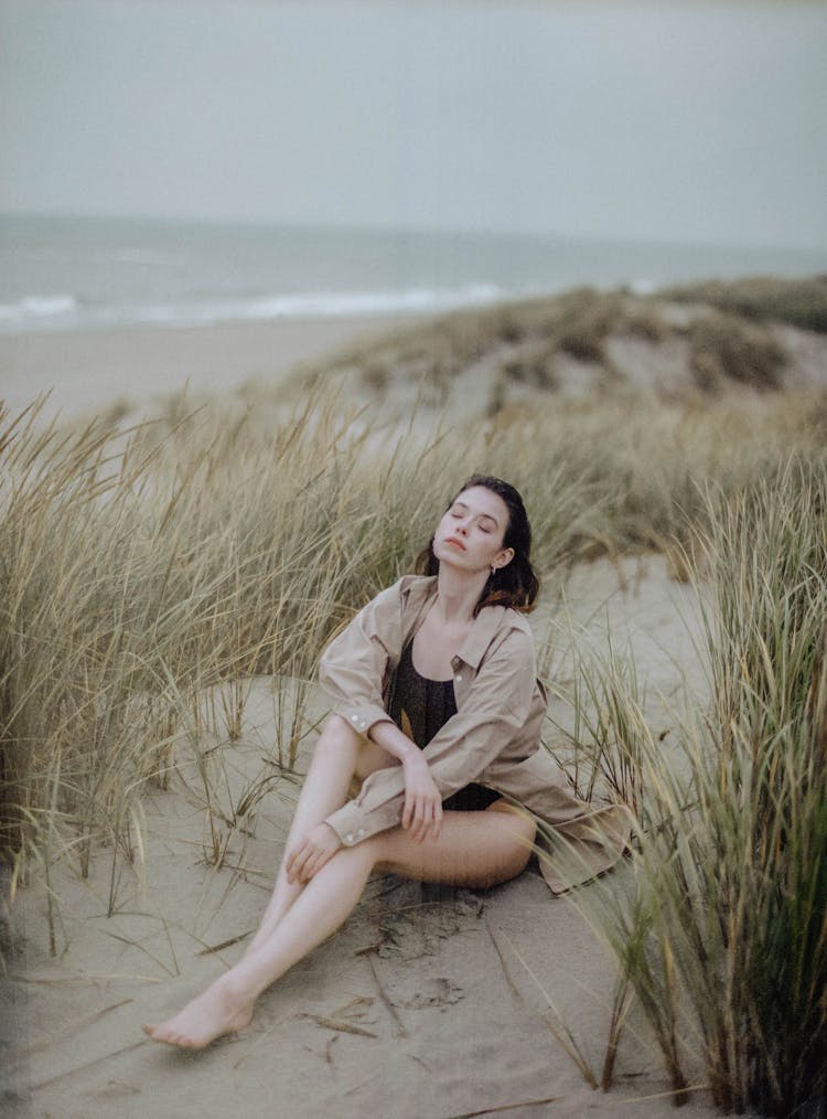 Woman Wearing Unbuttoned Brown Long Sleeves Sitting On Sand 