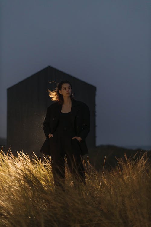 Free Woman in Black Blazer Standing on Brown Grass Field Stock Photo
