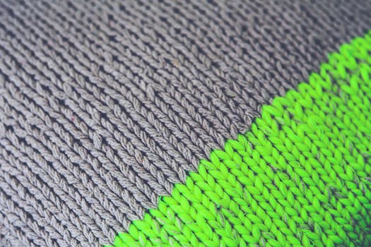Detailed view of beige and lime woolen knit fabric showcasing texture and pattern.
