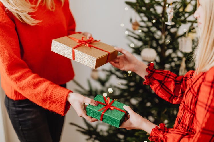 People Wearing Red Clothes Exchanging Gift Boxes 