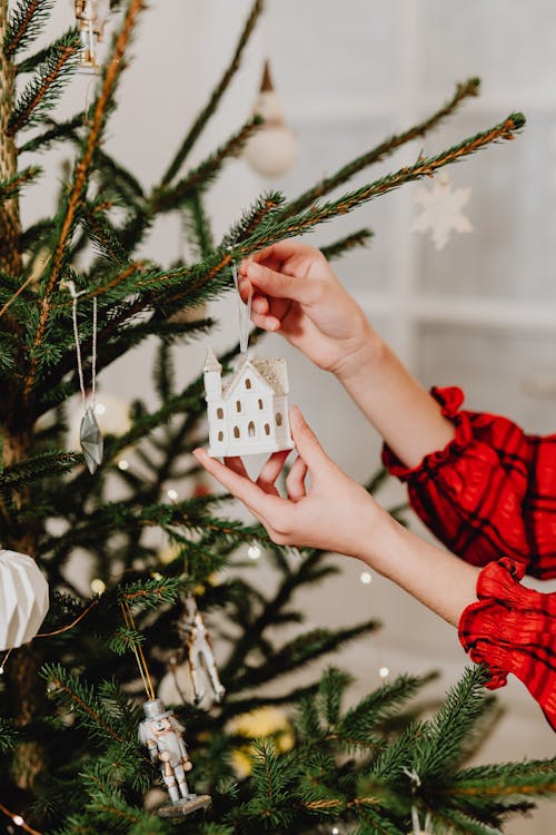 Woman Hanging an Ornament on a Christmas Tree