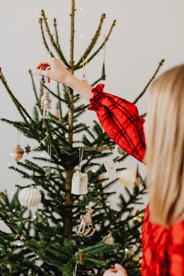 Blond Girl Decorating A Christmas Tree