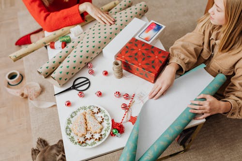 Woman in Brown Jacket Holding Green and White Wrapping Paper