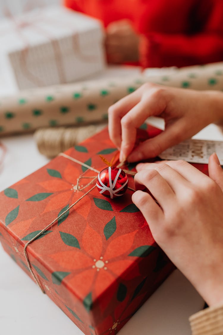 Close Up Of Girls Hands Wrapping Christmas Gift