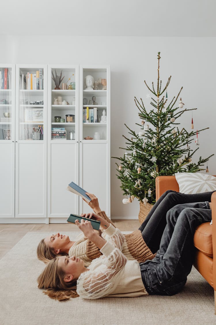 Teenager And Her Mother Reading Books At Christmas