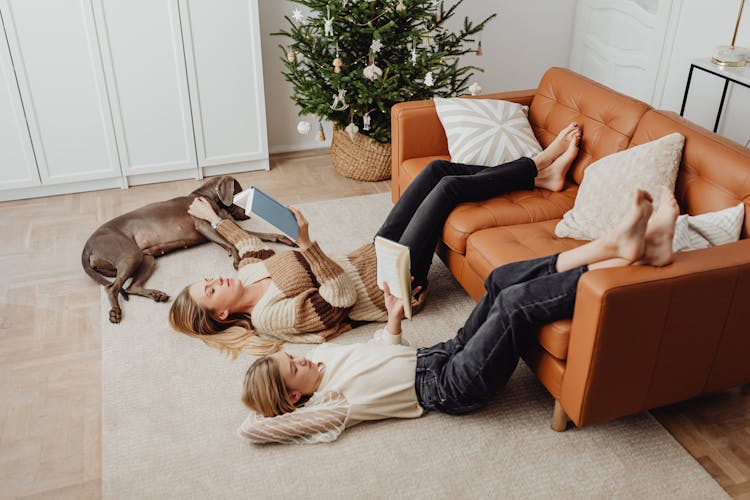 Woman And Teenager Relaxing With Books At Christmas Time