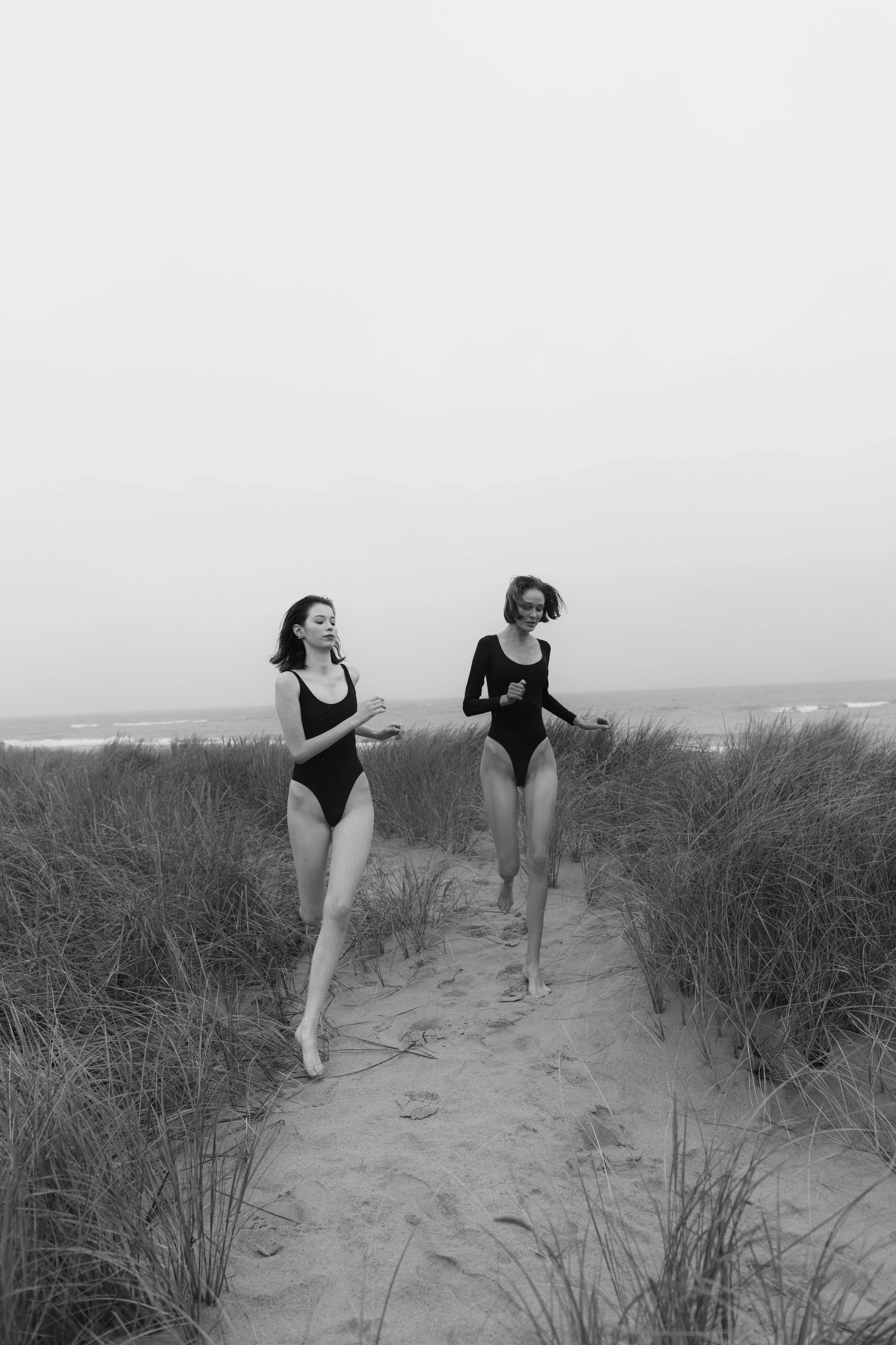 monochrome photo of two women wearing black bodysuit