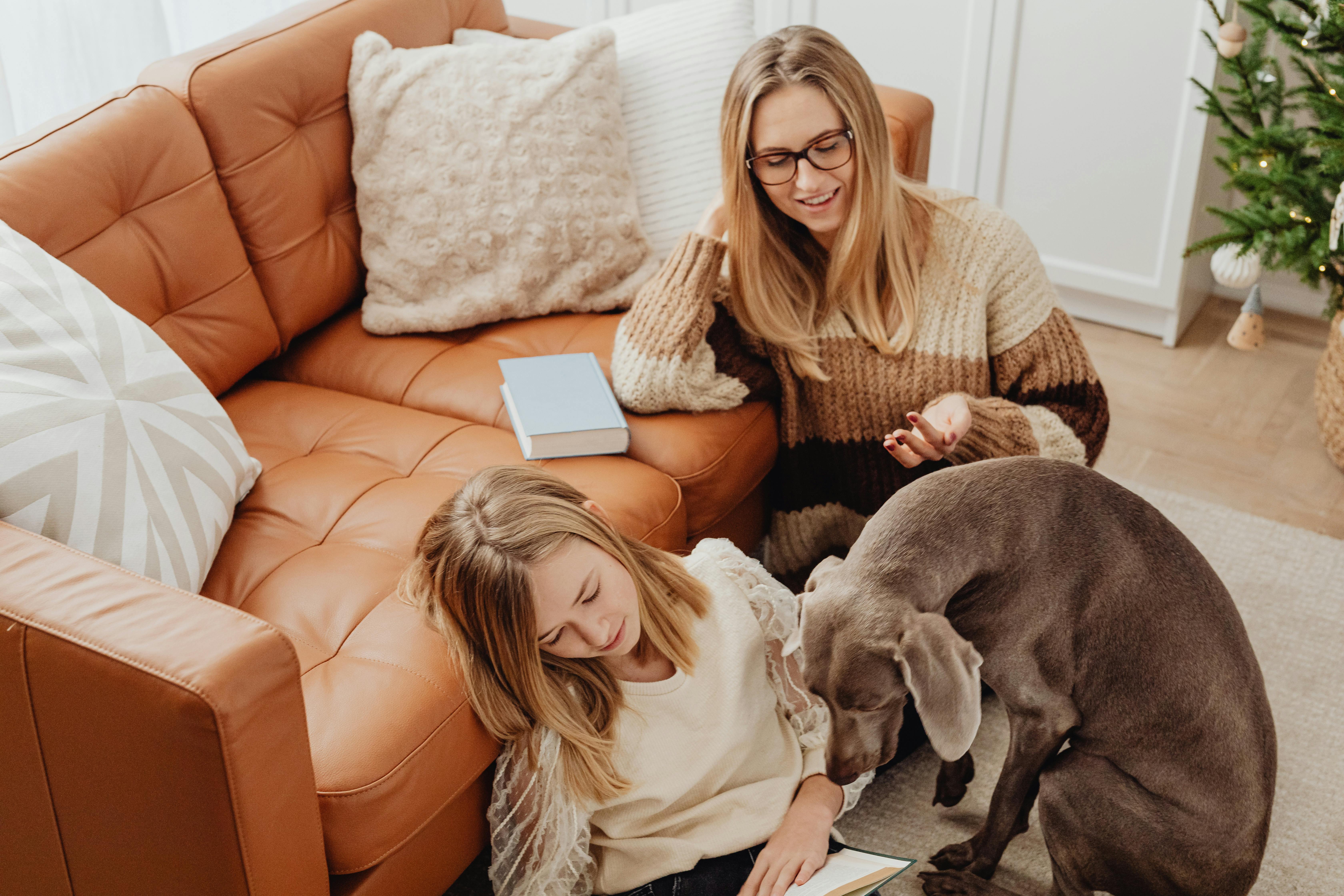 a dog sitting beside the girl in white long sleeves