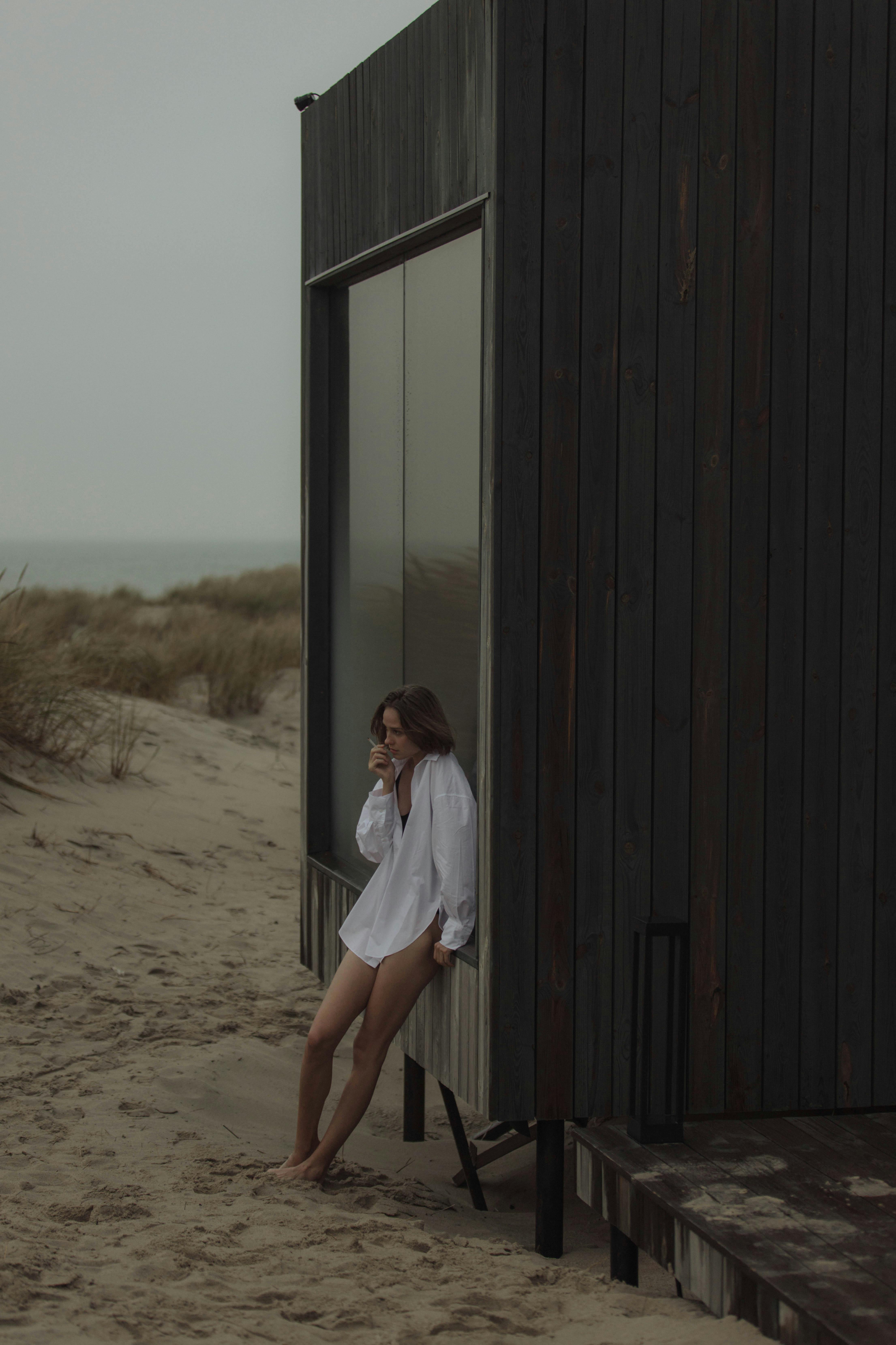 woman in white long sleeve shirt and white skirt standing on brown sand