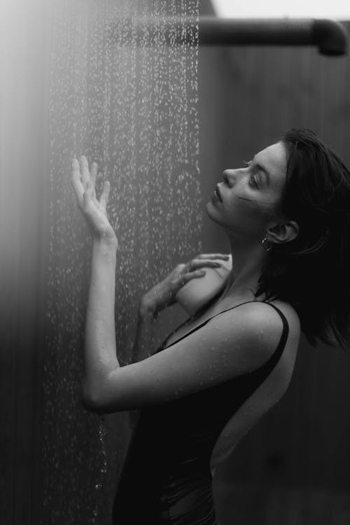Grayscale Photo of Woman Taking a Shower 