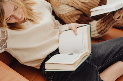 Woman in White Sweater Holding a Book