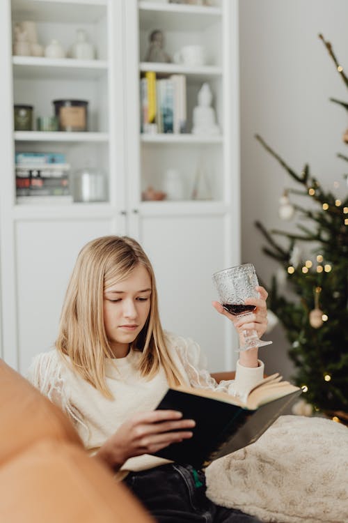 Woman Reading Book on a Sofa at Christmas 