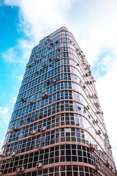Tall glass office building with a cloudy backdrop in São Paulo, Brazil.