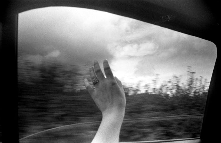 Woman Putting Hand Out The Car Window 