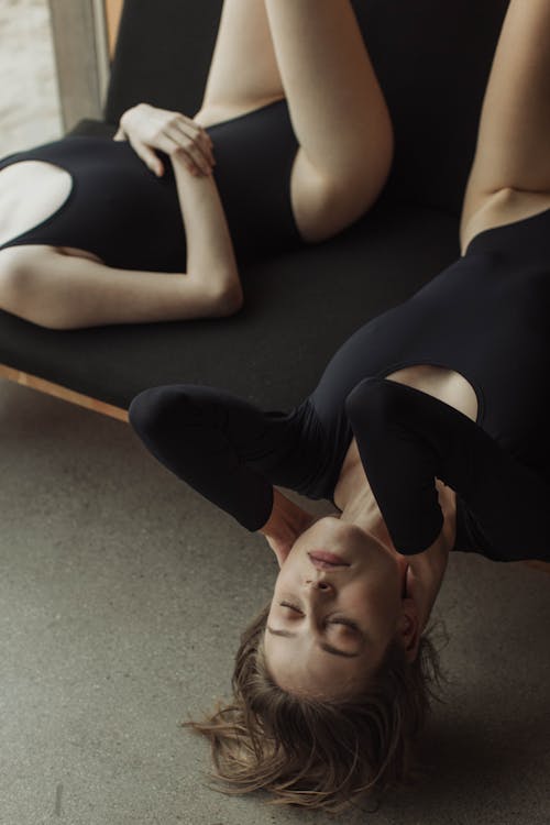 Free Women in Bodysuits Lying Down on a Chair Stock Photo